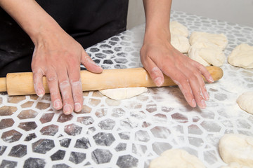 sheeting the dough with a rolling pin in the kitchen