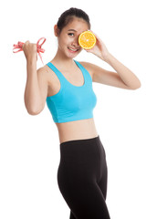 Asian healthy girl on diet with orange fruit and measuring tape