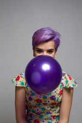 Violet short-haired girl  holding a balloon with her mouth, look