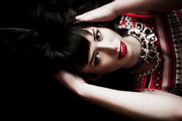 A woman wearing a leather jacket and red pattern dress