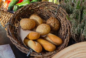 Buns and baguettes on a table in a wicker basket. Food