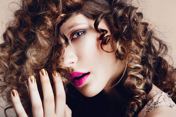 Portrait of a beautiful young girl with curly hair in the studio, the concept of health and beauty