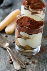 tiramisu in glass on wooden surface