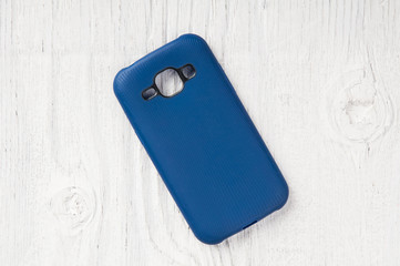 Blue plastic mobile phone cover wooden background