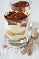 tiramisu in glass on wooden surface