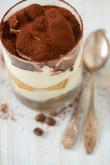 tiramisu in glass on wooden surface