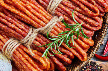 Cheese and chili snack stick sausages in a wooden basket
