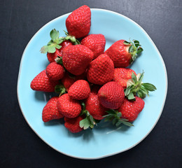 Strawberris on plate on blackboard