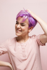 Violet-short-haired woman in pink pastel.holding her hair with o