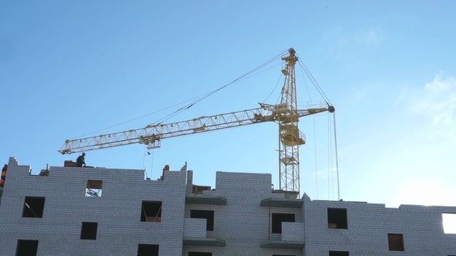 Construction crane, workers work in construction