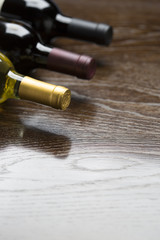 Obraz na płótnie Canvas Various Wine Bottles on Reflective Wood Surface Abstract