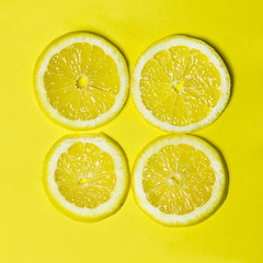 Four Lemon Slices on Yellow Background