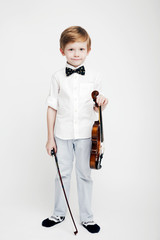 Little cute red-haired boy with a violin in his hands