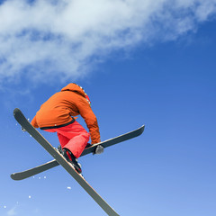 Skier doing high jump above the mountain