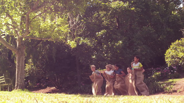  Children having a sack race in park