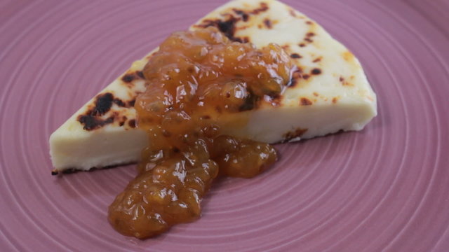 Finnish squeaky cheese with cloudberry jam on a purple plate