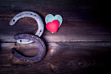 Old Rusty Lucky Horseshoes And Two Hearts On Wooden Boards In Vintage Style. Lucky And Love Concept.