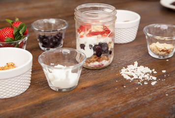 Jar of yogurt with many ingredients on a table