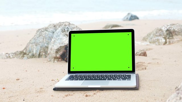 laptop on the beach, keylight green background.
