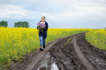 Woman walking along the road with a bouquet.