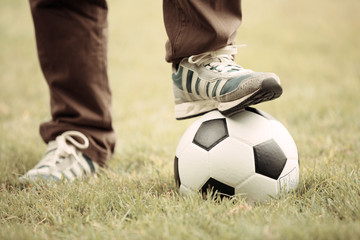 Close up of feet on top of soccer ball