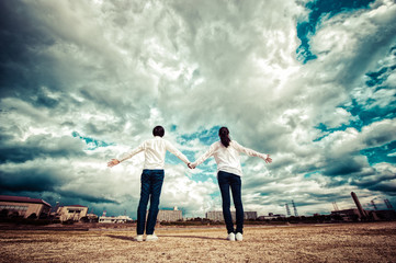 空に向かって手を広げる男女