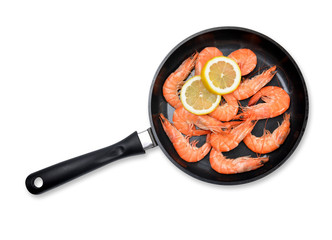 Skillet with shrimp and lemon isolated on white background.