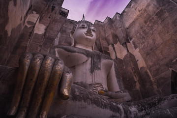 ancient seated buddha staue in the temple ruins of sukhothai in