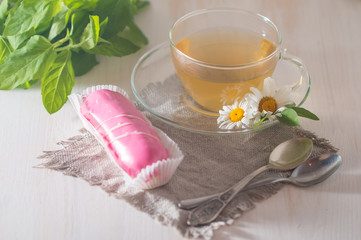 cup of chamomile tea with pink eclair