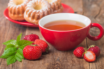 black english tea in red cup with strawberry
