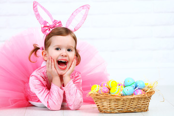 Happy child girl in a costume Easter bunny rabbit with basket of