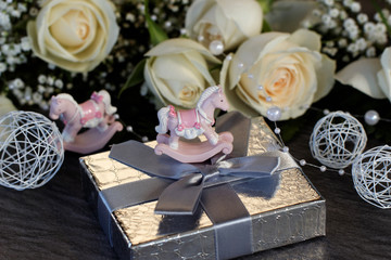 Geschenk mit Schaukelpferd und Rosen
