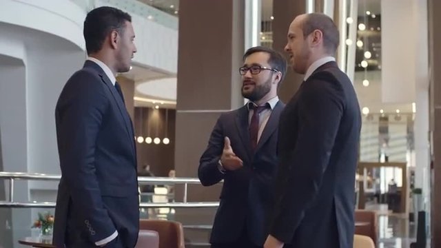 Business partners meeting in business center, shaking hands and greeting each other