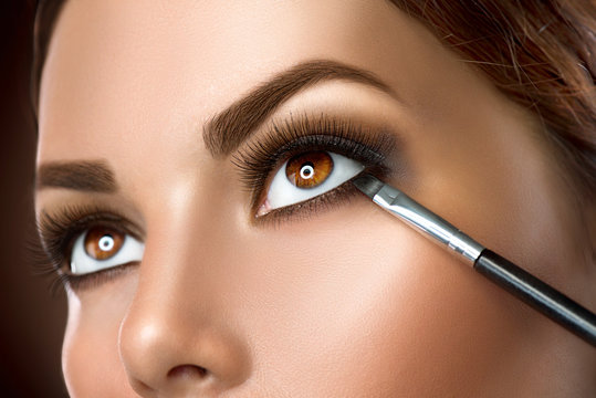 Woman applying makeup closeup. Eyeliner - Powered by Adobe