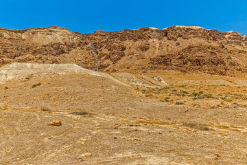 Israelis dry and sandy stone desert landscape by the Dead sea.