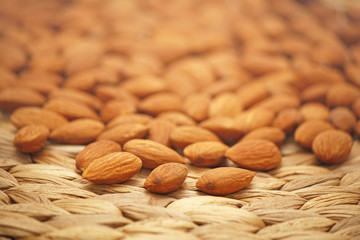 Almonds on straw background.