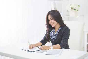 Young smiling business woman working on her paperwork