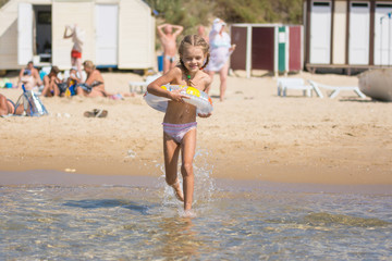 Happy girl running to swim in the sea