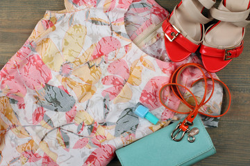 multi colored dress with purse and shoes on a wooden table