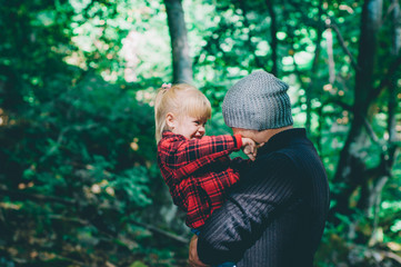 Young father with his little daughter having fun in the forest