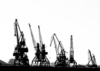 Грузовые судна-подъемные краны на реке в морском порту (черно-белая фотография)
