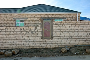 Door in unfinished building standing above ground level. A funny looking stage in building,...