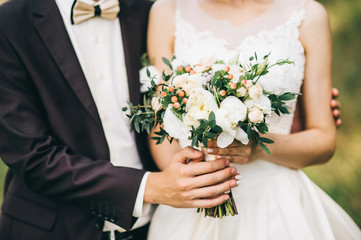 Groom hugs bride. bridal bouquet