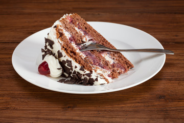 Ein Stück Schwarzwälder Kirschtorte, Holzhintergrund