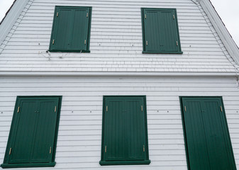 Green Shutters on Old White Wood Building
