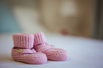 View of baby shoes on a bed