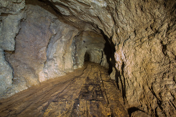 Old abandoned gold mine tunnel passage with yellow sulfur dirt