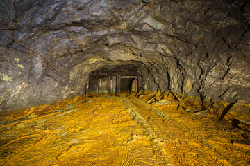 Old abandoned gold mine tunnel passage with yellow sulfur dirt