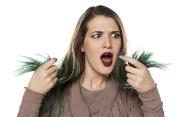 unsatisfied young woman looking at her green tail