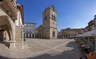Guimaraes, Portugal - Oktober 2015: Menschen genießen die Esplanaden auf dem Oliveira-Platz mit der Kirche Nossa Senhora da Oliveira, dem Salado-Denkmal und dem alten Rathaus. UNESCO-Weltkulturerbe.